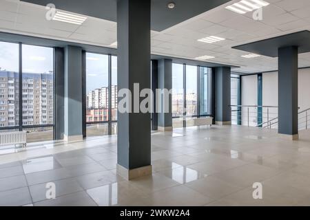 vista panoramica in una moderna sala vuota con colonne, porte, scale e finestre panoramiche. Foto Stock