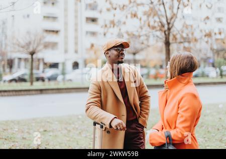 Adulti, compresi colleghi e imprenditori, in piedi all'aperto e con una conversazione positiva dopo il lavoro. Foto Stock