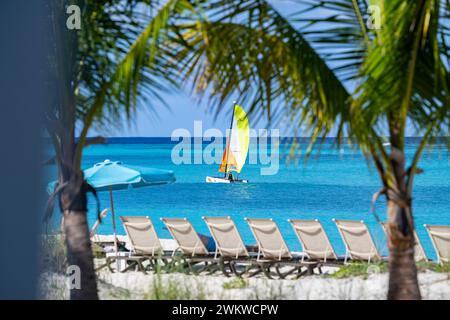 San Salvador Island Bahamas, catamarano che naviga sulle acque turchesi, cielo quasi nuvoloso, vele colorate, acque cristalline e calme, sport eccitanti, gioia Foto Stock