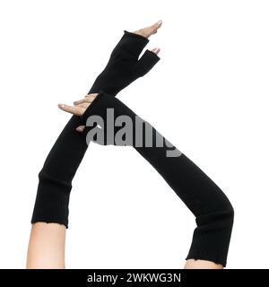 Mani femminili aggraziate in lunghi guanti senza dita in lana nera con guantoni su sfondo bianco primo piano Foto Stock