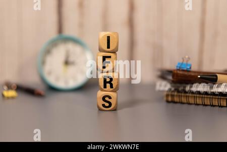 C'è un cubo di legno con la parola IFRS. È l'abbreviazione di International Financial Reporting Standard come immagine accattivante. Foto Stock