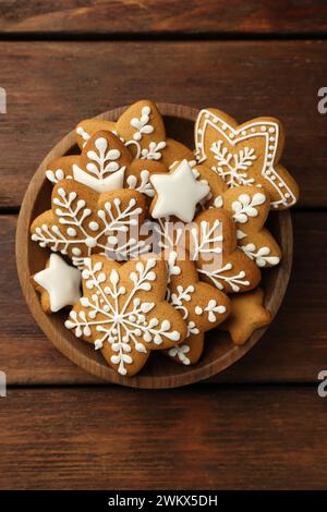 Gustosi biscotti di Natale con glassa nel recipiente su un tavolo di legno, vista dall'alto Foto Stock