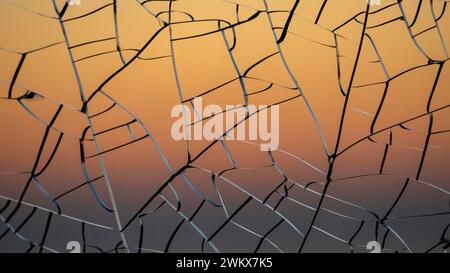 Sfumatura del tramonto attraverso il vetro incrinato Foto Stock