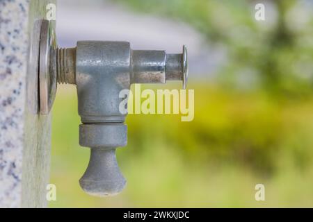 Primo piano del rubinetto d'acqua sulla fontana di marmo nel parco pubblico della Corea del Sud Foto Stock