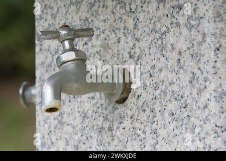 Primo piano del rubinetto d'acqua sulla fontana di marmo nel parco pubblico della Corea del Sud Foto Stock