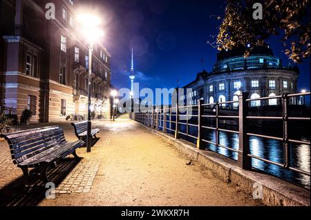 In una tranquilla serata a Berlino, le rive del fiume Sprea vicino all'Isola dei Musei rivelano una scena serena, con panchine che adornano il passaggio pedonale. Foto Stock