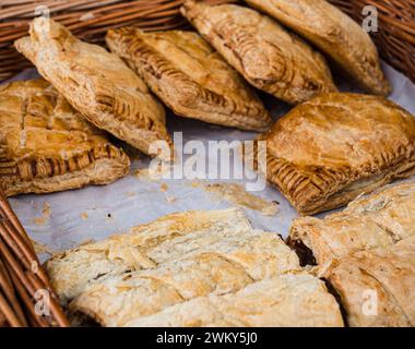 Un cestino di wicket pieno di pasticci biologici della Cornovaglia appena sfornati al mercato agricolo di Waddesdon Manor. Foto Stock