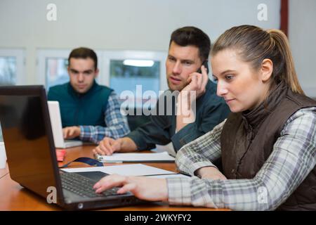 lavoratrice donna che mostra i dati nel notebook al lavoratore di magazzino Foto Stock