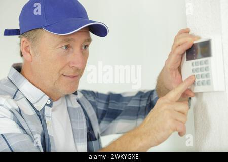 uomo maturo che preme i pulsanti sulla tastiera elettronica Foto Stock