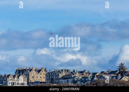 Un singolo falco rosso della Royal Air Force che vola sopra la città costiera di Lossiemouth Foto Stock