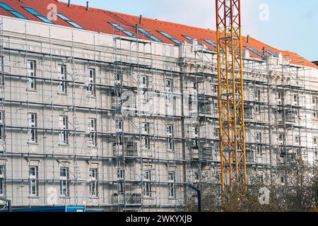 Nel mezzo dello skyline della città, le impalcature si aggrappano a strutture torreggianti, che mostrano l'intricata danza dell'architettura e della costruzione Foto Stock