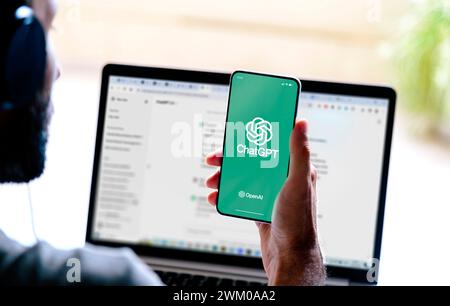 Uomo che utilizza ChatGPT nel telefono cellulare e nel portatile. Questa app è un chatbot basato sull'intelligenza artificiale sviluppato da OpenAI. ROSARIO, ARGENTINA - Foto Stock