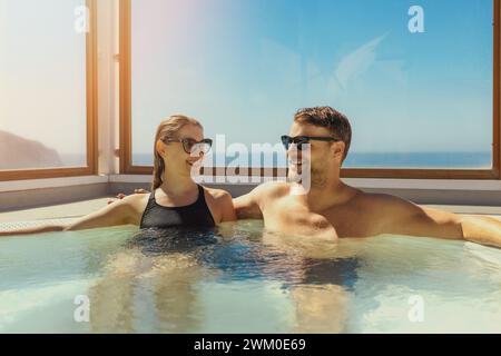 coppia che si rilassa nella jacuzzi sul tetto nella giornata di sole. vacanze estive, viaggi brevi Foto Stock