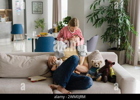 Padre e figlia trascorrono il tempo libero insieme sul divano di casa Foto Stock