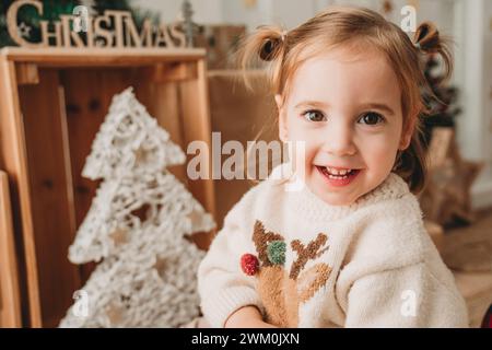 Ragazza felice vicino alla decorazione di Natale a casa Foto Stock