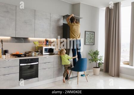 Uomo che fissa l'armadio vicino a Son a casa Foto Stock