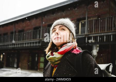 Giovane donna premurosa di fronte all'edificio Foto Stock