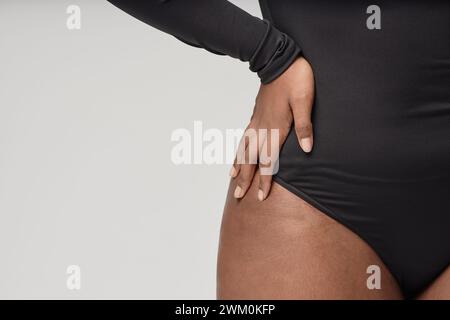 Donna che indossa un body nero su sfondo bianco Foto Stock