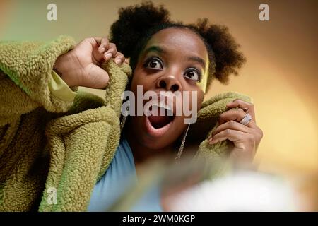 Donna sorpresa che indossa un cappotto in pelliccia sintetica Foto Stock