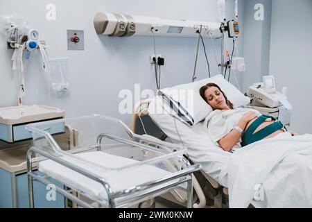 Donna incinta che riposa sul letto nella sala parto Foto Stock