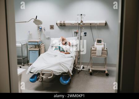 Donna incinta che dorme a letto in ospedale Foto Stock