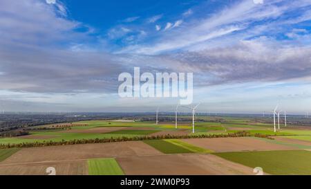 Vista aerea delle nuvole sui campi di campagna con parco eolico sullo sfondo Foto Stock
