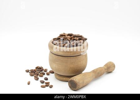 Chicchi di caffè e un macinacaffè in legno all'interno di una tazza su un tavolo bianco Foto Stock