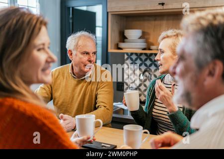 Amici che parlano a tavola Foto Stock