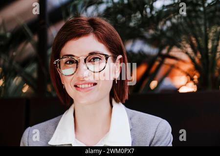 Imprenditrice sorridente indossando occhiali da vista Foto Stock