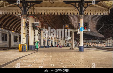 Una piattaforma della stazione ferroviaria, fiancheggiata da colonne curve, in un atrio principale. Una storica tettoia del XIX secolo è in alto e un treno aspetta in un lato. Foto Stock