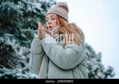 Donna che si riscalda le mani in inverno Foto Stock