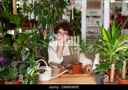 Una pianta di vaso botanico sorridente a tavola in negozio Foto Stock