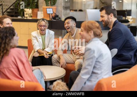 Colleghi soddisfatti e diversificati che discutono della strategia durante le riunioni sul luogo di lavoro Foto Stock