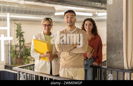 Giovani colleghi d'affari multirazziali sorridenti in ufficio Foto Stock
