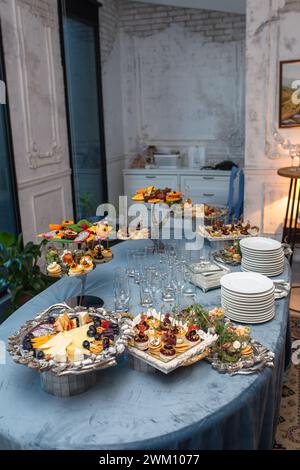 Un tavolo a buffet ben organizzato con una variegata selezione di frutta fresca, formaggi assortiti e gustosi antipasti. Foto Stock