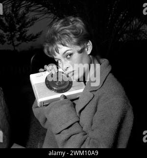 3823852 Brigitte Bardot, Roma, 1960 (foto b/n); (add.info.: Roma, 1960. L'attrice francese Brigitte Bardot nella sua casa romana con una radio / Roma, 1960.); © Marcello Mencarini. Tutti i diritti riservati 2024. Foto Stock