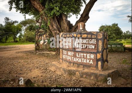 Un cartello costruito in pietra all'ingresso del Parco Nazionale di Mikumi in Tanzania avverte la gente che non si sporca e dà indicazioni. Foto Stock