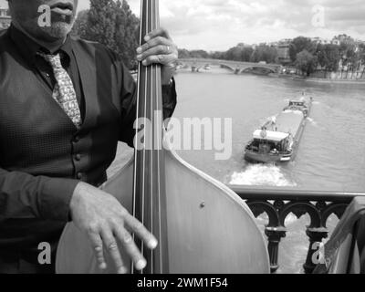 4068197 musicista di strada che suona il contrabbasso al Pont d'Arcole sulla Senna, con una mouche di bateau sullo sfondo; (add.info.: 24 ore a Parigi Musicista di strada che suona il contrabbasso sul Pont d'Arcole sopra la Senna con un bateau mouche passa sullo sfondo); © Marcello Mencarini. Tutti i diritti riservati 2024. Foto Stock