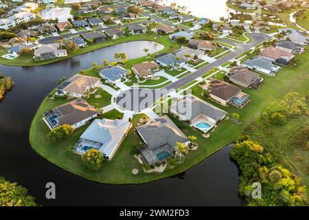 Vista aerea delle case private nell'area residenziale della Florida al tramonto. Nuove case familiari come esempio di sviluppo immobiliare nei sobborghi americani Foto Stock