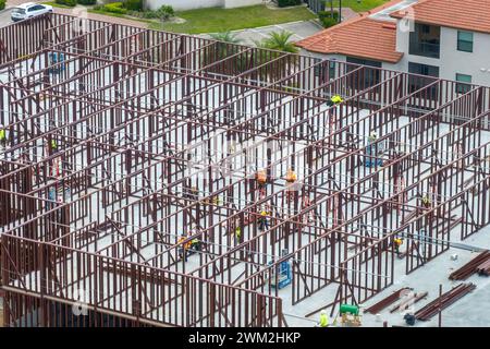 Cantiere con molti lavoratori e attrezzature a Fort Myers, Florida. Lavoro duro nello sviluppo commerciale. Foto Stock