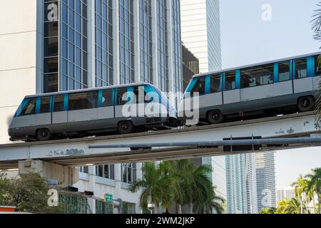 Trasporto pubblico in treno sopraelevato nel quartiere del centro di Miami in Florida USA. Treno Metrorail su alta ferrovia oltre il traffico stradale tra Foto Stock