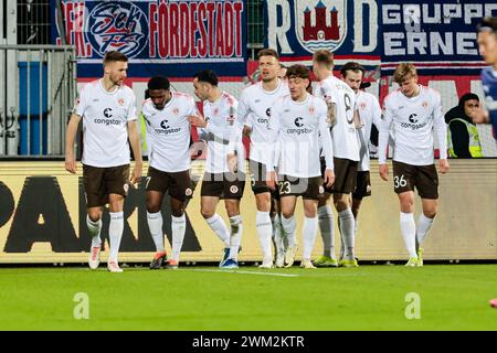 Kiel, Germania. 24 febbraio 2024. Calcio: Bundesliga 2, Holstein Kiel - FC St. Pauli, Matchday 23, Holstein Stadium. St I giocatori di Pauli fanno il tifo dopo il goal 1:0. Credito: Frank Molter/dpa - NOTA IMPORTANTE: in conformità con i regolamenti della DFL German Football League e della DFB German Football Association, è vietato utilizzare o far utilizzare fotografie scattate nello stadio e/o della partita sotto forma di immagini sequenziali e/o serie di foto video./dpa/Alamy Live News Foto Stock