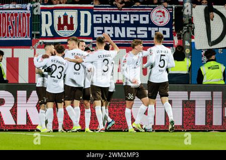 Kiel, Germania. 24 febbraio 2024. Calcio: Bundesliga 2, Holstein Kiel - FC St. Pauli, Matchday 23, Holstein Stadium. St I giocatori di Pauli fanno il tifo dopo il goal 1:0. Credito: Frank Molter/dpa - NOTA IMPORTANTE: in conformità con i regolamenti della DFL German Football League e della DFB German Football Association, è vietato utilizzare o far utilizzare fotografie scattate nello stadio e/o della partita sotto forma di immagini sequenziali e/o serie di foto video./dpa/Alamy Live News Foto Stock