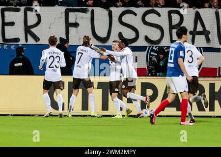 Kiel, Germania. 24 febbraio 2024. Calcio: Bundesliga 2, Holstein Kiel - FC St. Pauli, Matchday 23, Holstein Stadium. St I giocatori di Pauli fanno il tifo dopo il goal 1:0. Credito: Frank Molter/dpa - NOTA IMPORTANTE: in conformità con i regolamenti della DFL German Football League e della DFB German Football Association, è vietato utilizzare o far utilizzare fotografie scattate nello stadio e/o della partita sotto forma di immagini sequenziali e/o serie di foto video./dpa/Alamy Live News Foto Stock