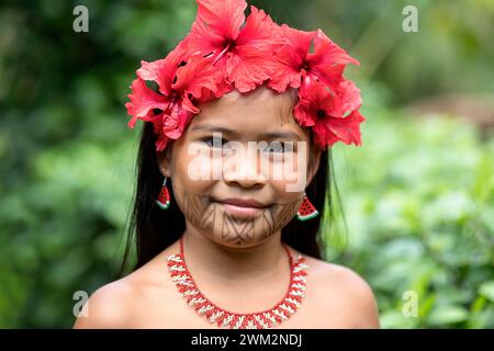 Ritratto di una ragazza della tribù Embera di un villaggio nel parco nazionale di Chagres con tatuaggi tradizionali sul viso e fiori di ibisco in capelli, Panama Foto Stock