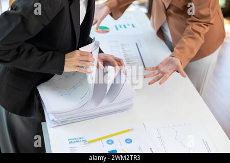 Un giovane segretario riceve una serie di documenti per trovare informazioni importanti che il manager dell'azienda può utilizzare in una riunione. Il concetto di trovare l'impor Foto Stock