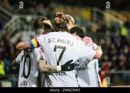 Kiel, Germania. 23 febbraio 2024. Calcio: Bundesliga 2, Holstein Kiel - FC St. Pauli, Matchday 23, Holstein Stadium. St I giocatori di Pauli tifanno il tifo dopo il gol per 4:1. Credito: Frank Molter/dpa - NOTA IMPORTANTE: in conformità con i regolamenti della DFL German Football League e della DFB German Football Association, è vietato utilizzare o far utilizzare fotografie scattate nello stadio e/o della partita sotto forma di immagini sequenziali e/o serie di foto video./dpa/Alamy Live News Foto Stock