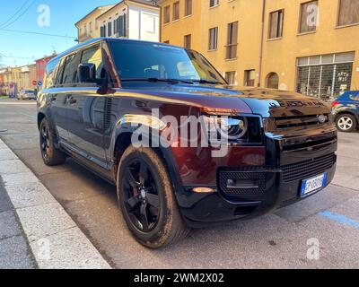 Cremona, Italia - 15 febbraio 2024 Land Rover Defender 130 se Sedona Red suv 4x4 in posizione di parcheggio. Foto Stock