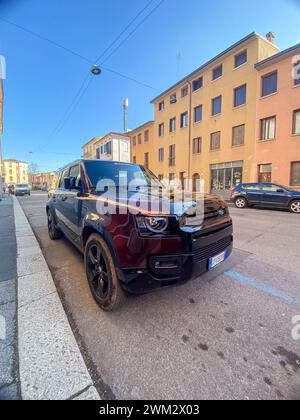 Cremona, Italia - 15 febbraio 2024 Land Rover Defender 130 se Sedona Red suv 4x4 in posizione di parcheggio. Foto Stock