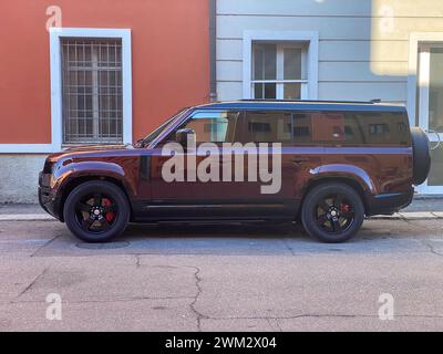 Cremona, Italia - 15 febbraio 2024 Land Rover Defender 130 se Sedona Red suv 4x4 in posizione di parcheggio. Foto Stock